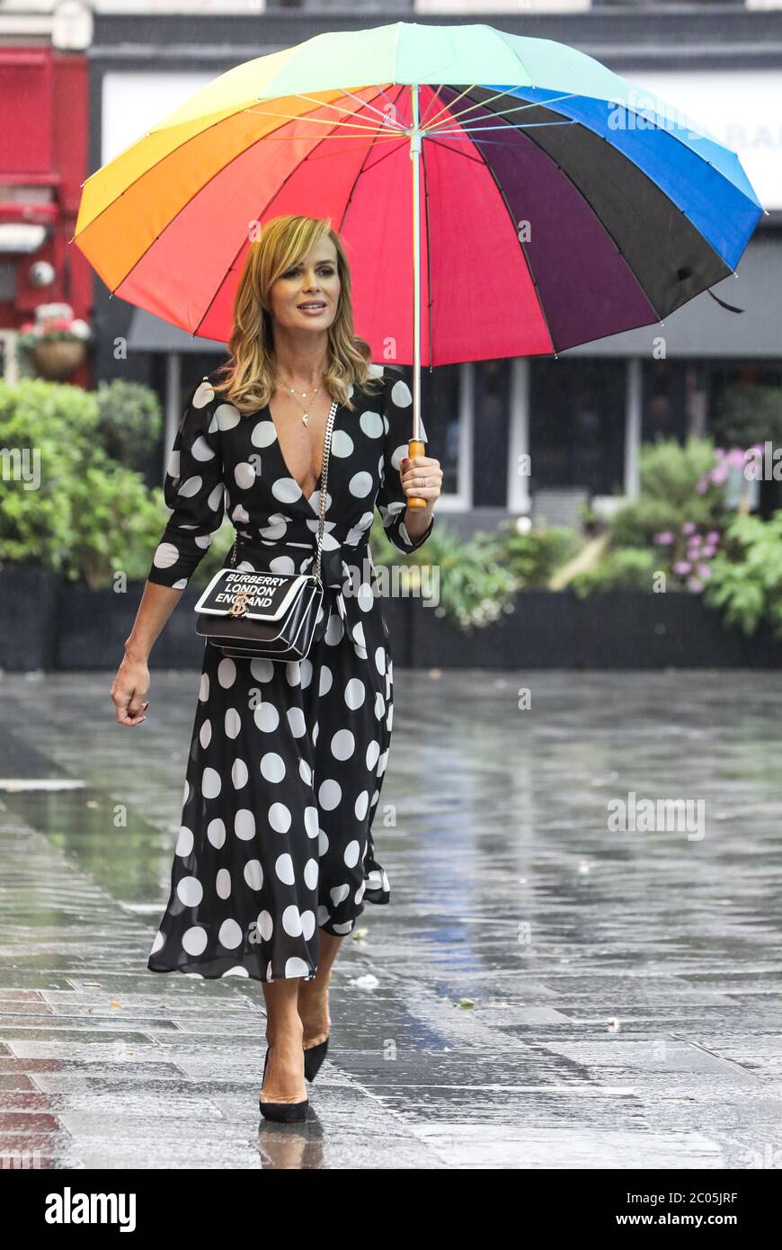 Amanda Holden a vu tenir un parapluie au départ des studios de radio Global à Londres. Banque D'Images