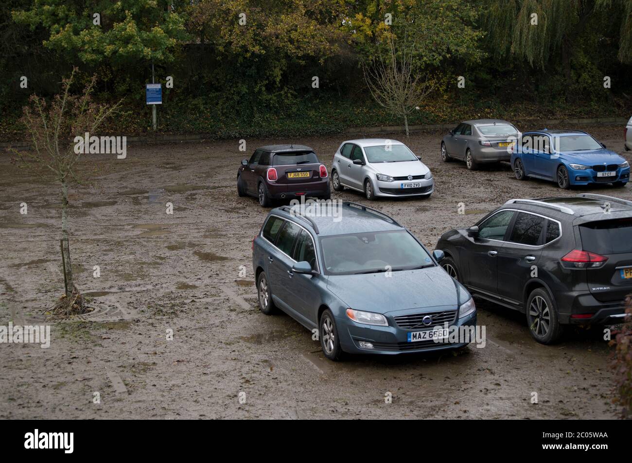 Les véhicules dans un parking boueux après les inondations se sont calmés à Market Harborough, Leicestershire, Angleterre. Banque D'Images