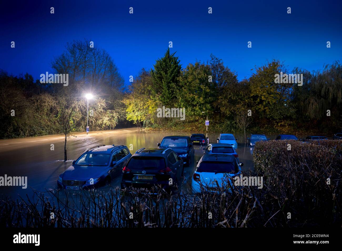 Voitures dans un parking inondé la nuit à Market Harborough, Leicestershire, Angleterre. Banque D'Images