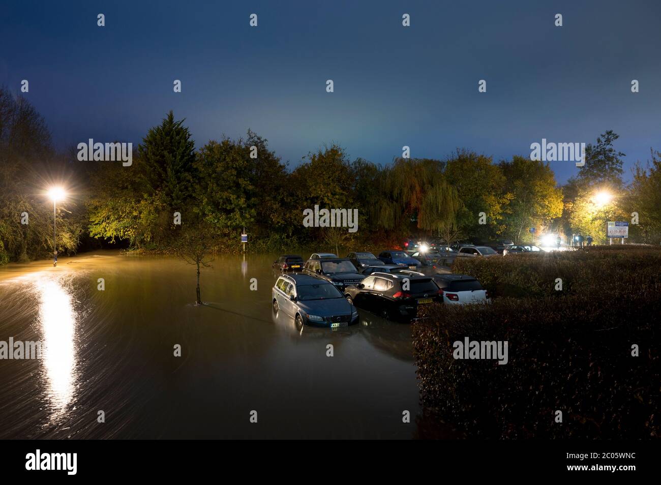 Voitures dans un parking inondé la nuit à Market Harborough, Leicestershire, Angleterre. Banque D'Images