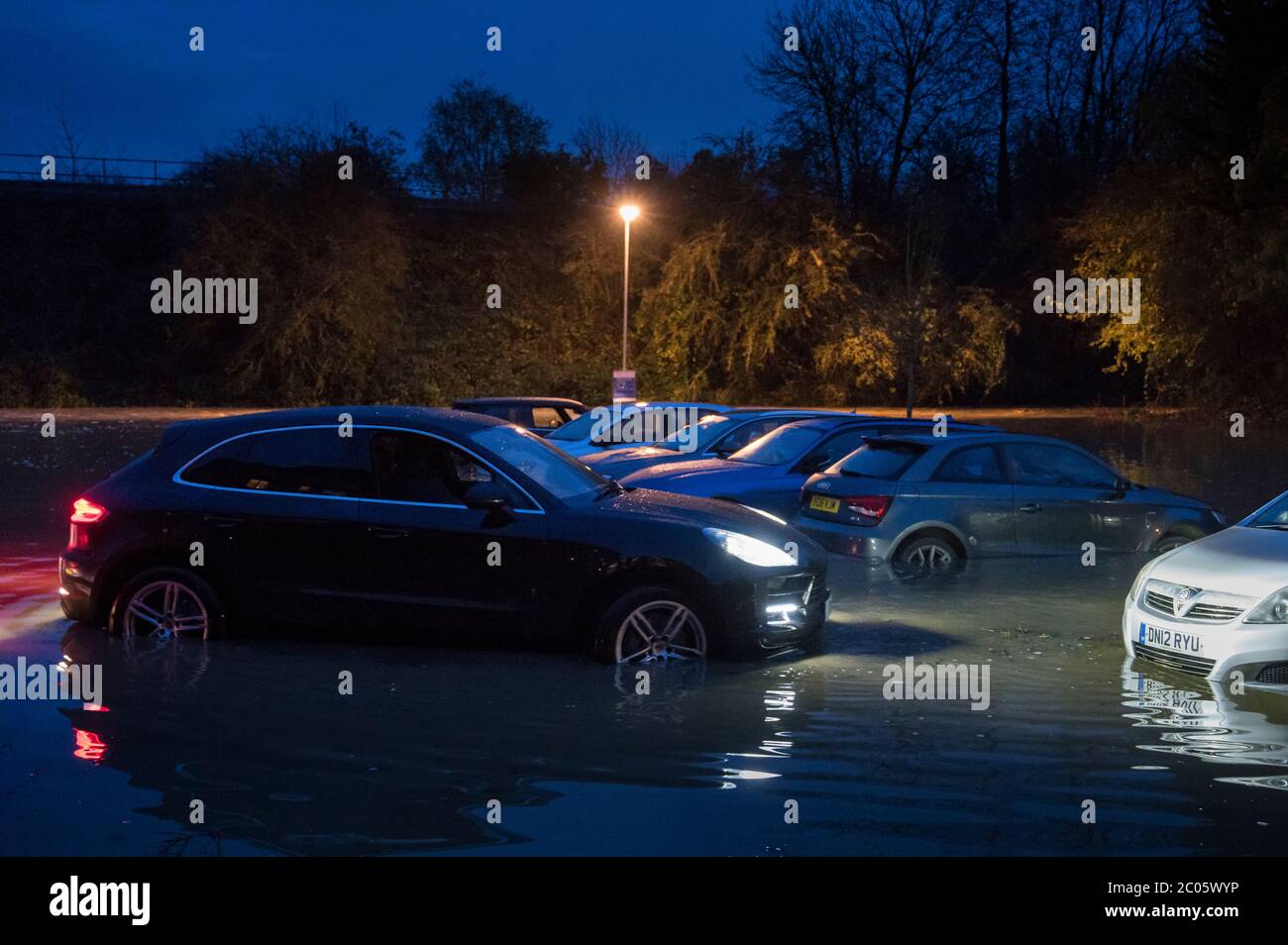 Voitures dans un parking inondé la nuit à Market Harborough, Leicestershire, Angleterre. Banque D'Images