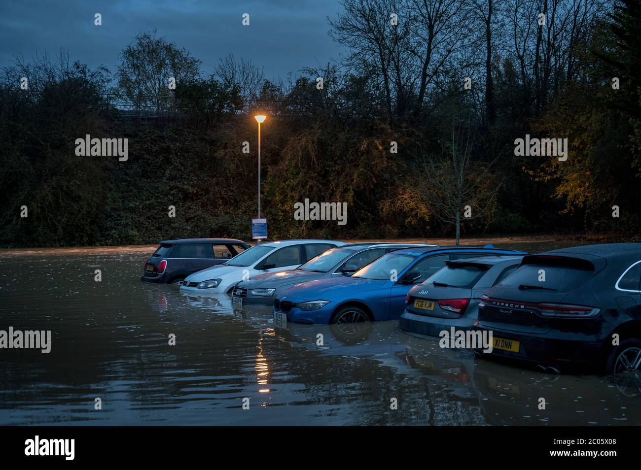 Voitures dans un parking inondé la nuit à Market Harborough, Leicestershire, Angleterre. Banque D'Images