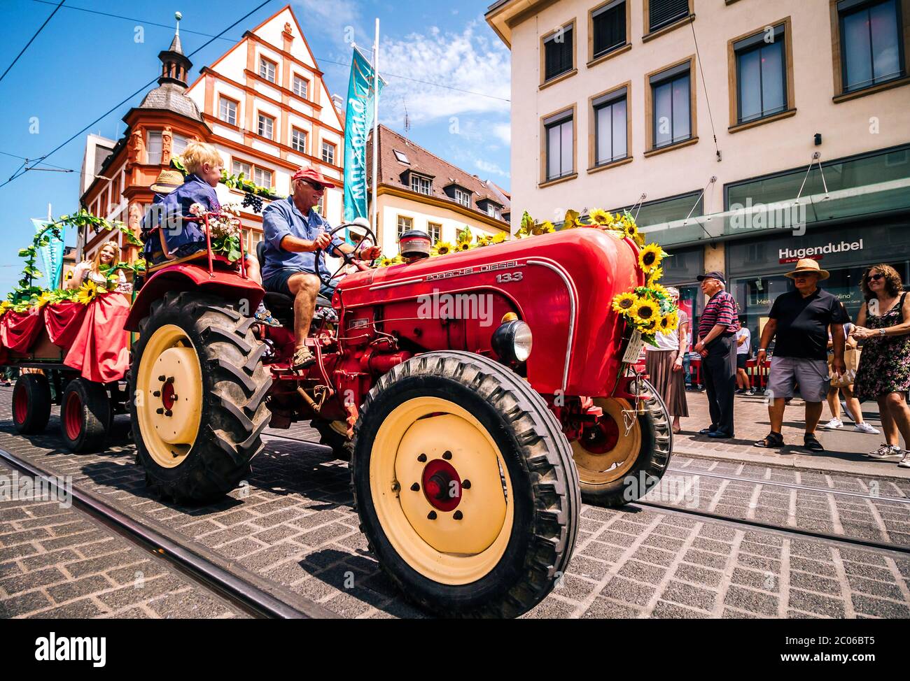 Vieux tracteur rouge décoré de façon traditionnelle lors du défilé d'ouverture du festival d'été. Kiliani est un immense festival folklorique de 2 semaines avec de la bière et de la musique de laiton. Banque D'Images
