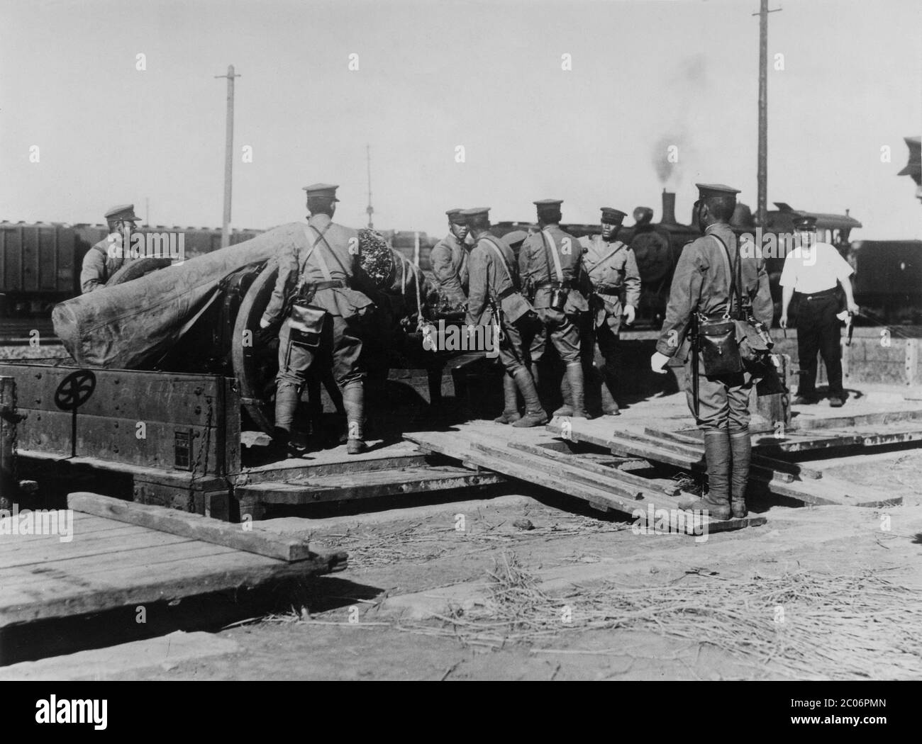 [ Japon des années 1930 - soldats japonais déchargeant des armes ] — soldats japonais déchargeant des armes de campagne à Mukden (aujourd'hui Shenyang), en Chine, en 1932 (Showa 7). L'année précédente, l'armée japonaise dans cette zone a organisé l'incident de Mukden qui a conduit le Japon à établir son état marionnette de Manchukuo le 1er mars 1932. imprimé argent gélatine vintage du xxe siècle. Banque D'Images