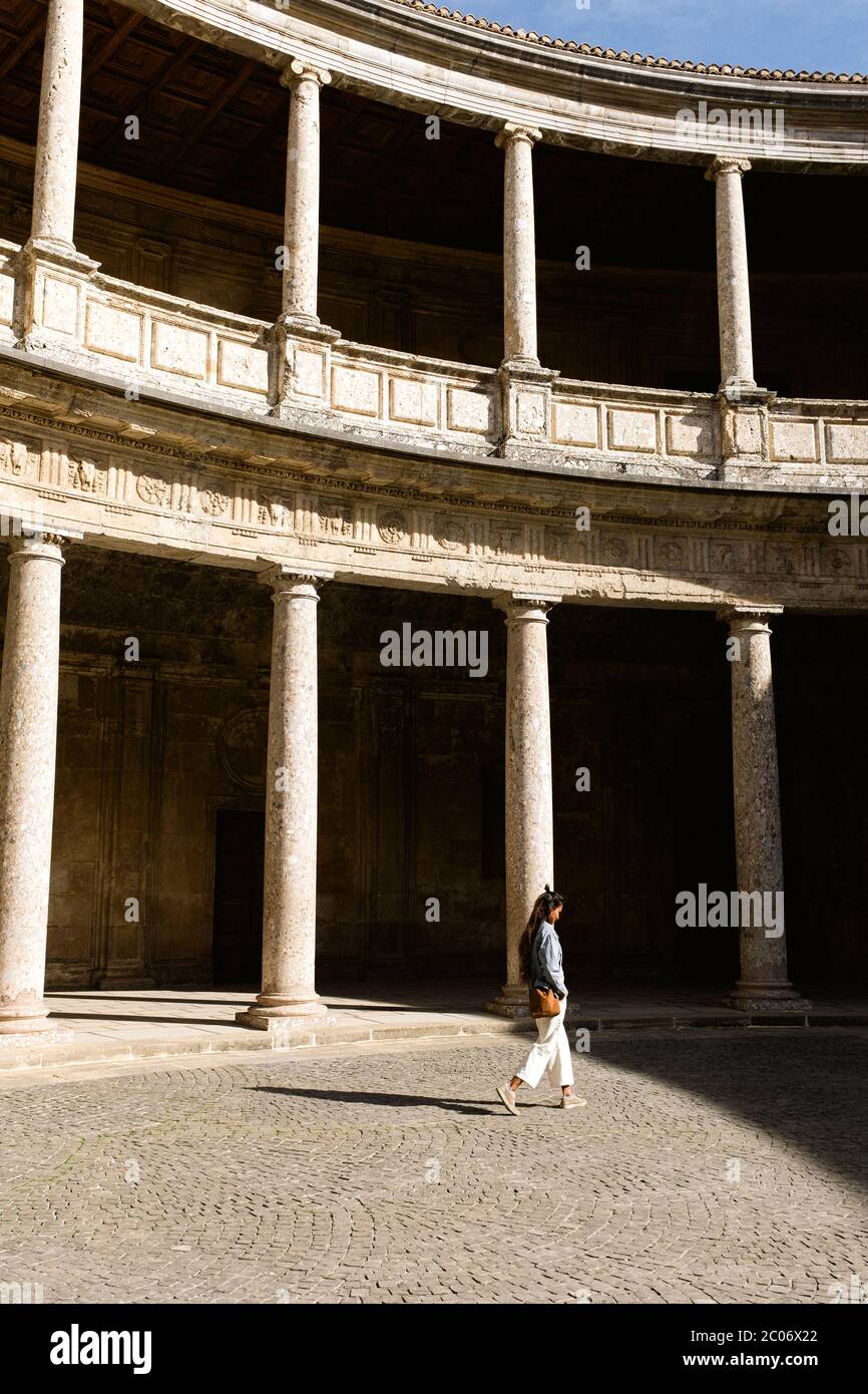 Une jeune femme marche dans la cour du Palais Charles V, à Grenade Banque D'Images