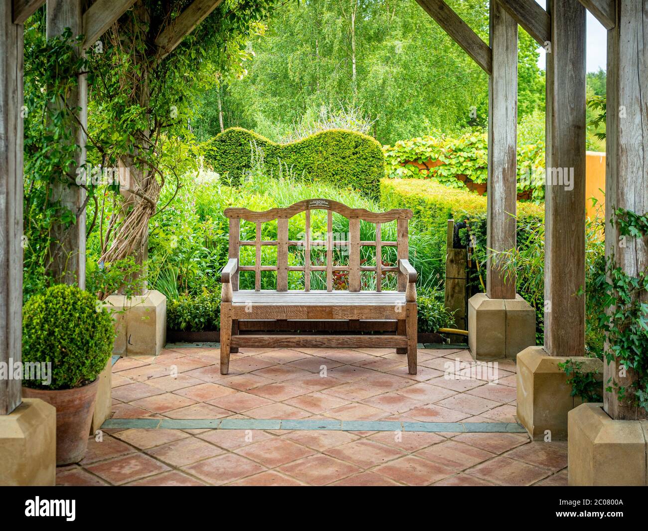 Siège de jardin vide en bois sous une pergola dans les jardins de Harlow Carr à Harrogate, Royaume-Uni Banque D'Images