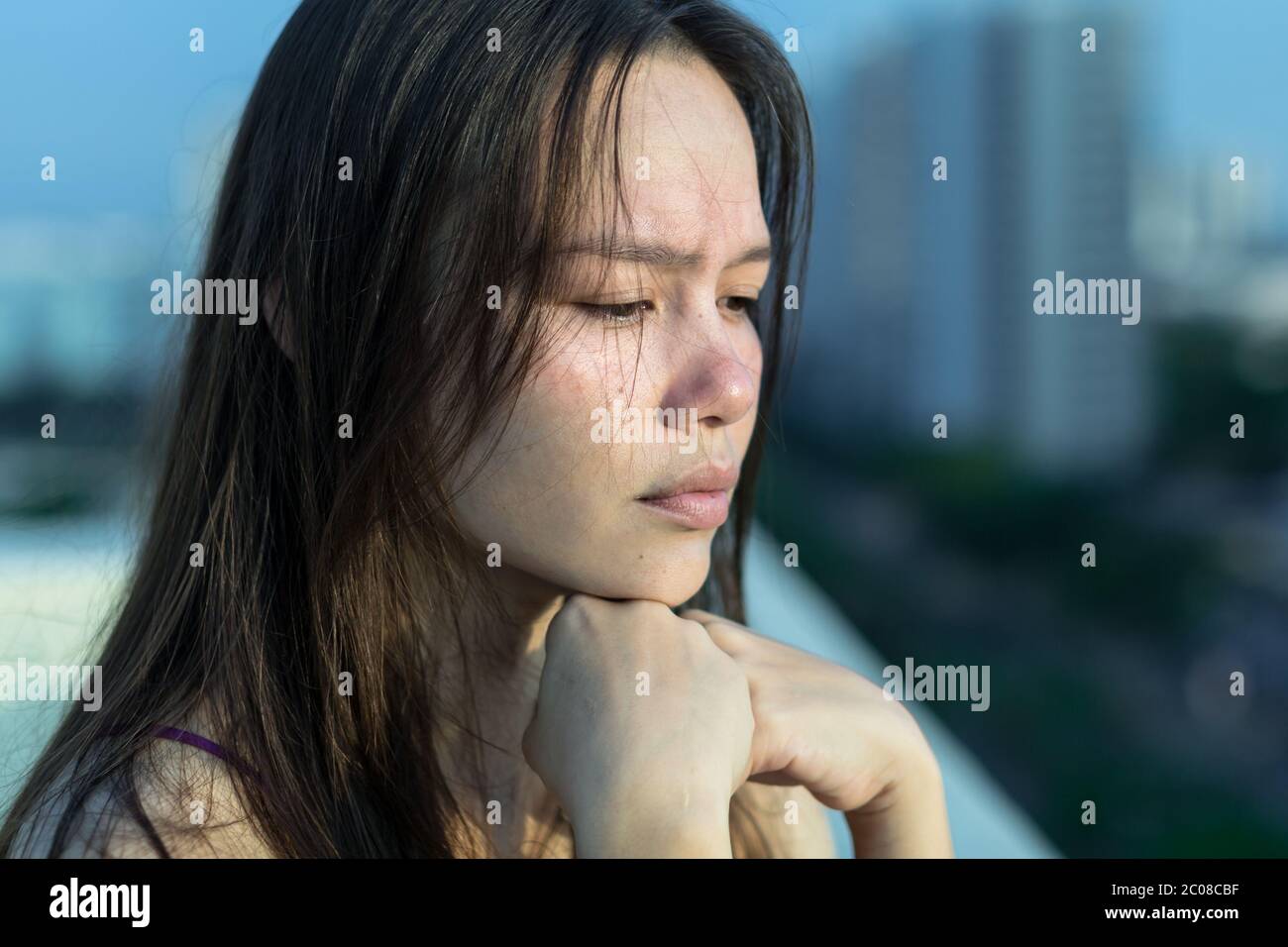 Jolie femme debout sur le toit émotive et se sentant malheureuse. Banque D'Images