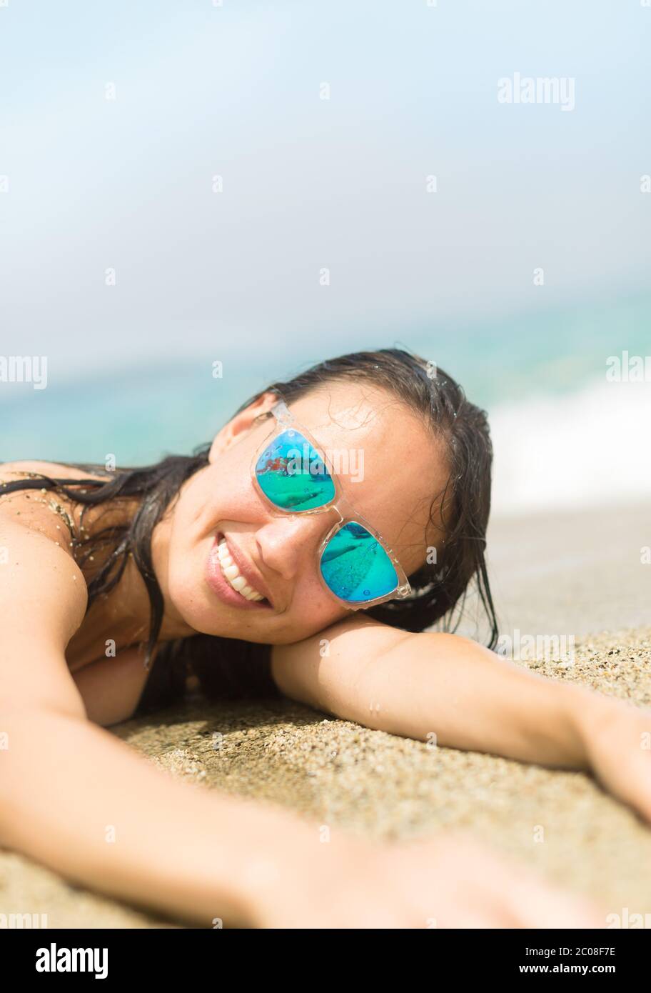 Bonne femme sur la rive en profitant du soleil et de l'eau en plein air. Vie sur l'île. Banque D'Images