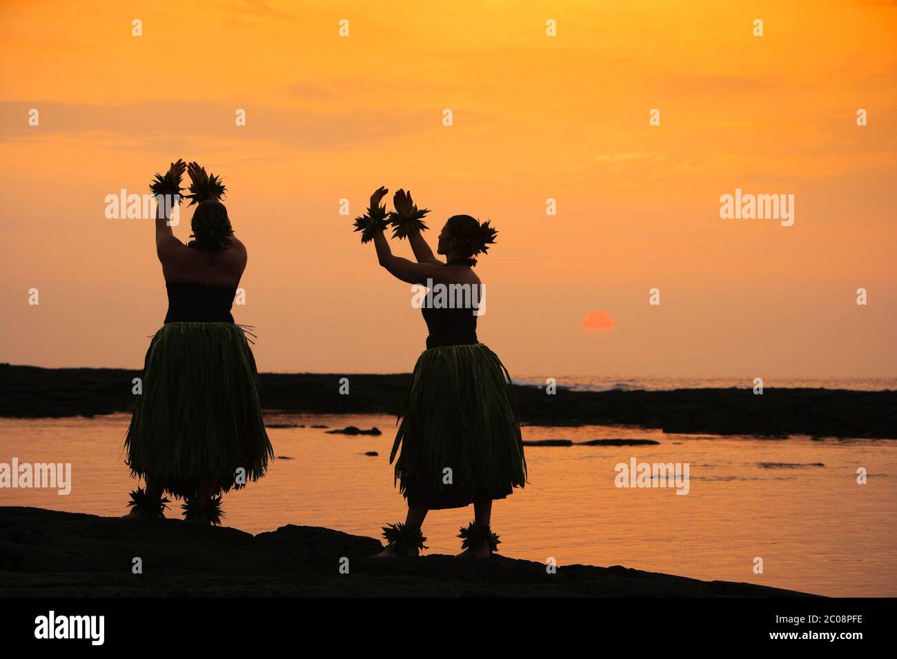 Danseurs hula traditionnels silhouettés (modèle sorti) au coucher du soleil au parc national Puuhonua O Honaunau à Hawaï Banque D'Images