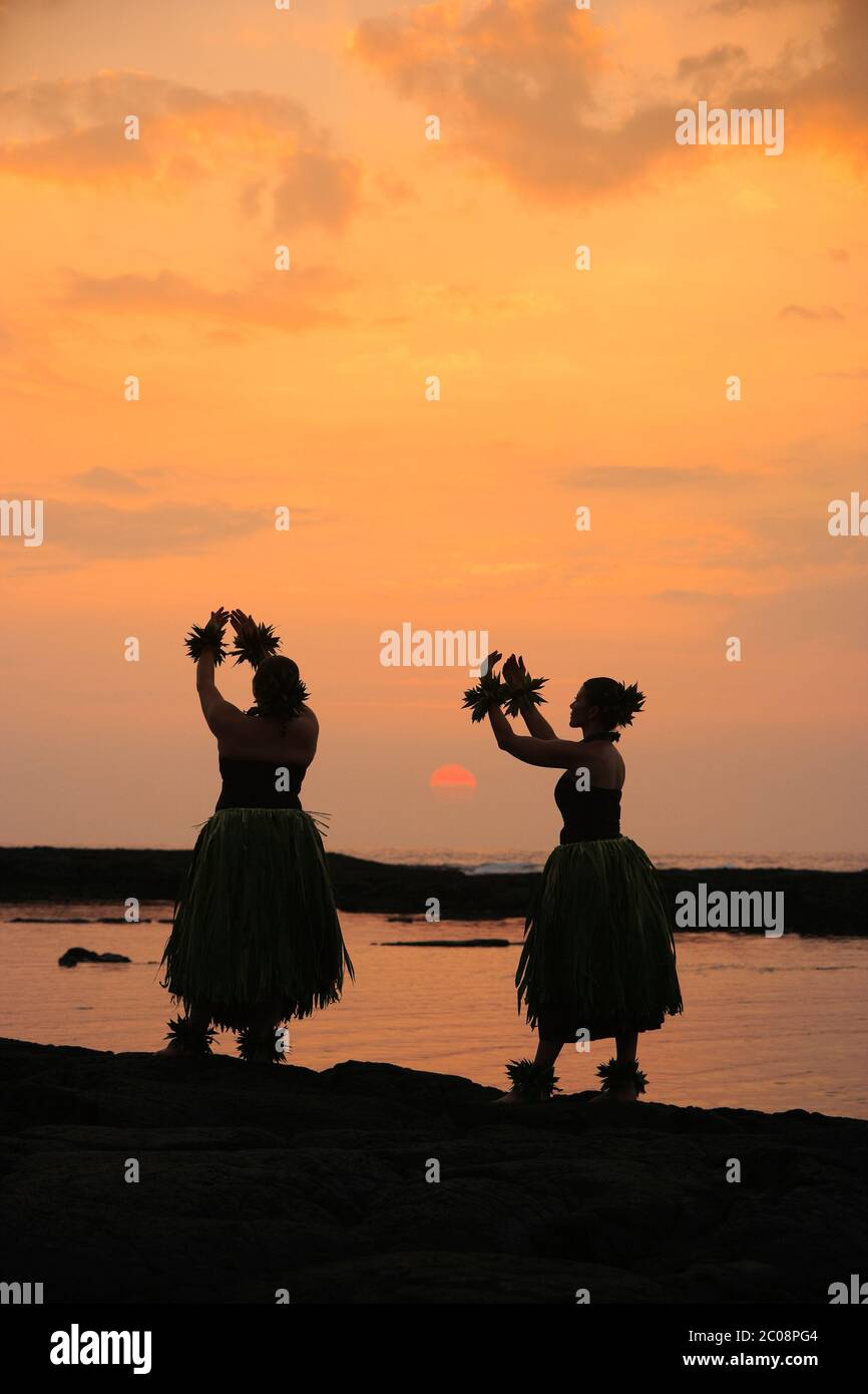 Danseurs hula traditionnels silhouettés (modèle sorti) au coucher du soleil au parc national Puuhonua O Honaunau à Hawaï Banque D'Images
