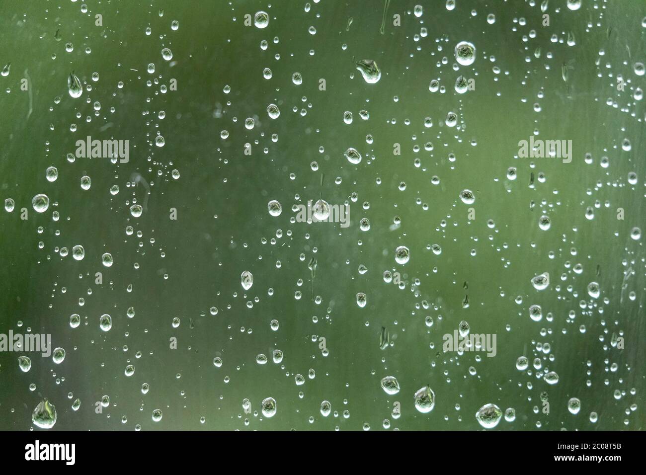 Gouttes de pluie sur une fenêtre depuis l'intérieur d'une maison. Banque D'Images
