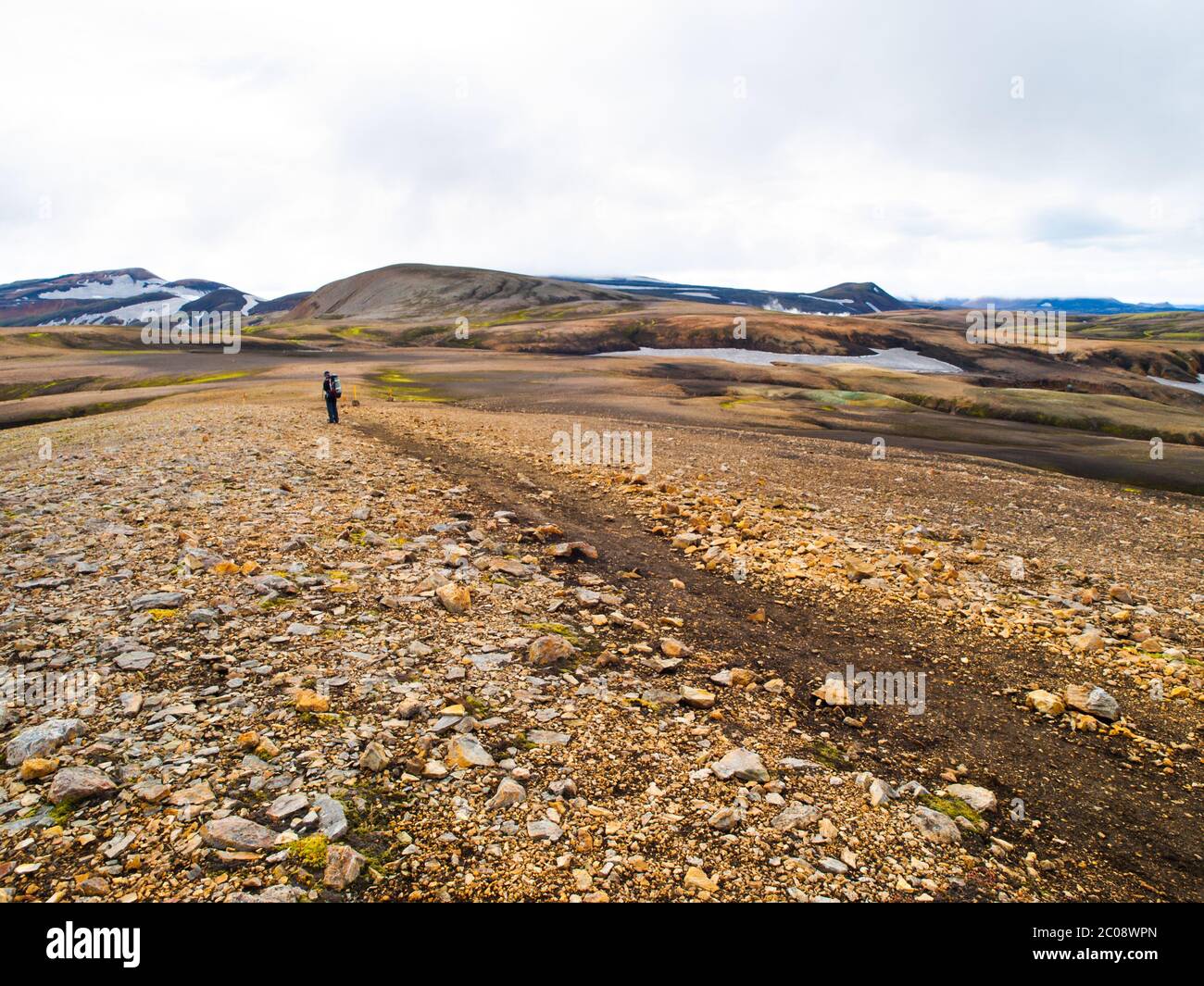 Sentier de montagne dans les montagnes Rainbow et promenades de randonneurs mâles sur elle, partie de Laugavegur Trail, Islande Banque D'Images