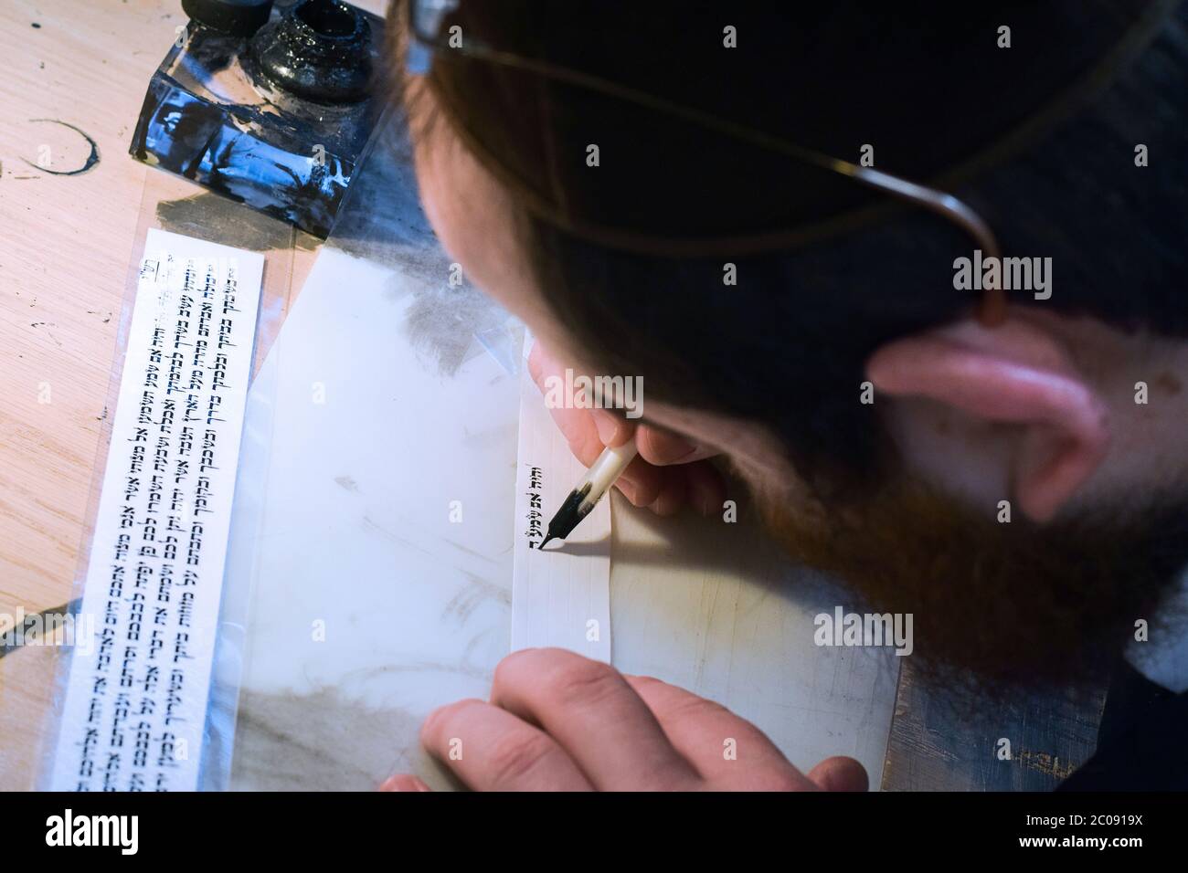 Un scribe juif écrit un verset de la Torah sur un petit morceau de parchemin à utiliser dans les phylatères - tefilin. À Crown Heights, Brooklyn, . Banque D'Images