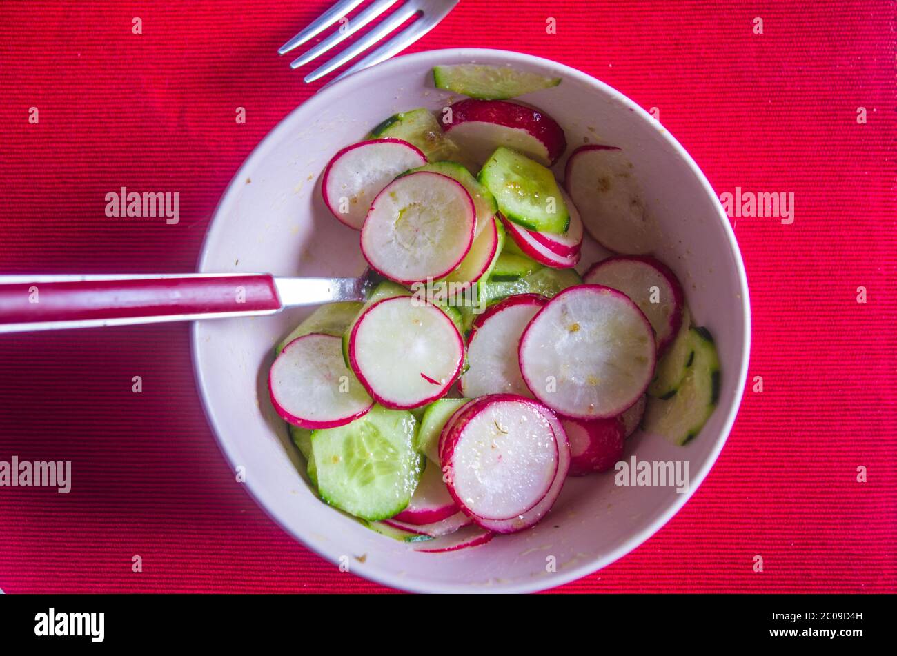 Salade de radis et de courgettes, nappée d'huile de vinagraitte, de sel, de poivre, de vinaigre et de jus de citron sur un nappe rouge écarlate Banque D'Images Salade de radis et de courgettes, nappée d'huile de vinagraitte, de sel, de poivre, de vinaigre et de jus de citron sur un nappe rouge écarlate Banque D'Images