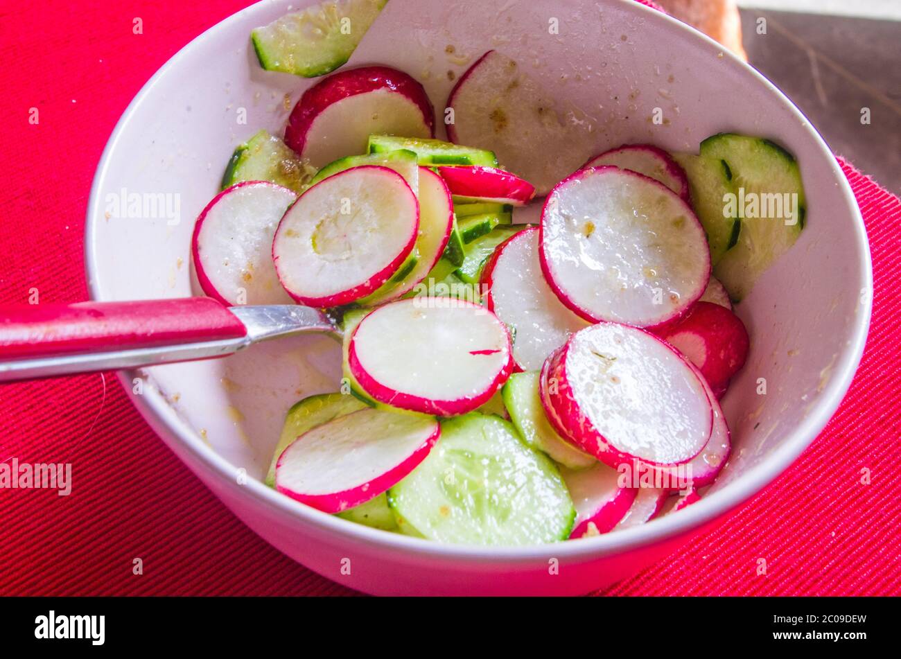 Salade de radis et de courgettes, nappée d'huile de vinagraitte, de sel, de poivre, de vinaigre et de jus de citron sur un nappe rouge écarlate Banque D'Images Salade de radis et de courgettes, nappée d'huile de vinagraitte, de sel, de poivre, de vinaigre et de jus de citron sur un nappe rouge écarlate Banque D'Images