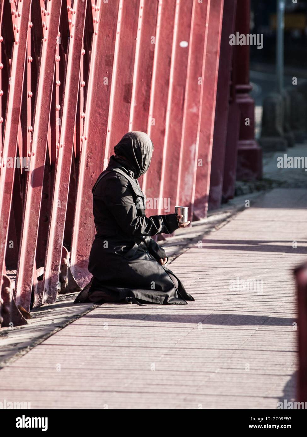 Femme musulmane vêtue de noir assise dans la rue et demandant des almes Banque D'Images