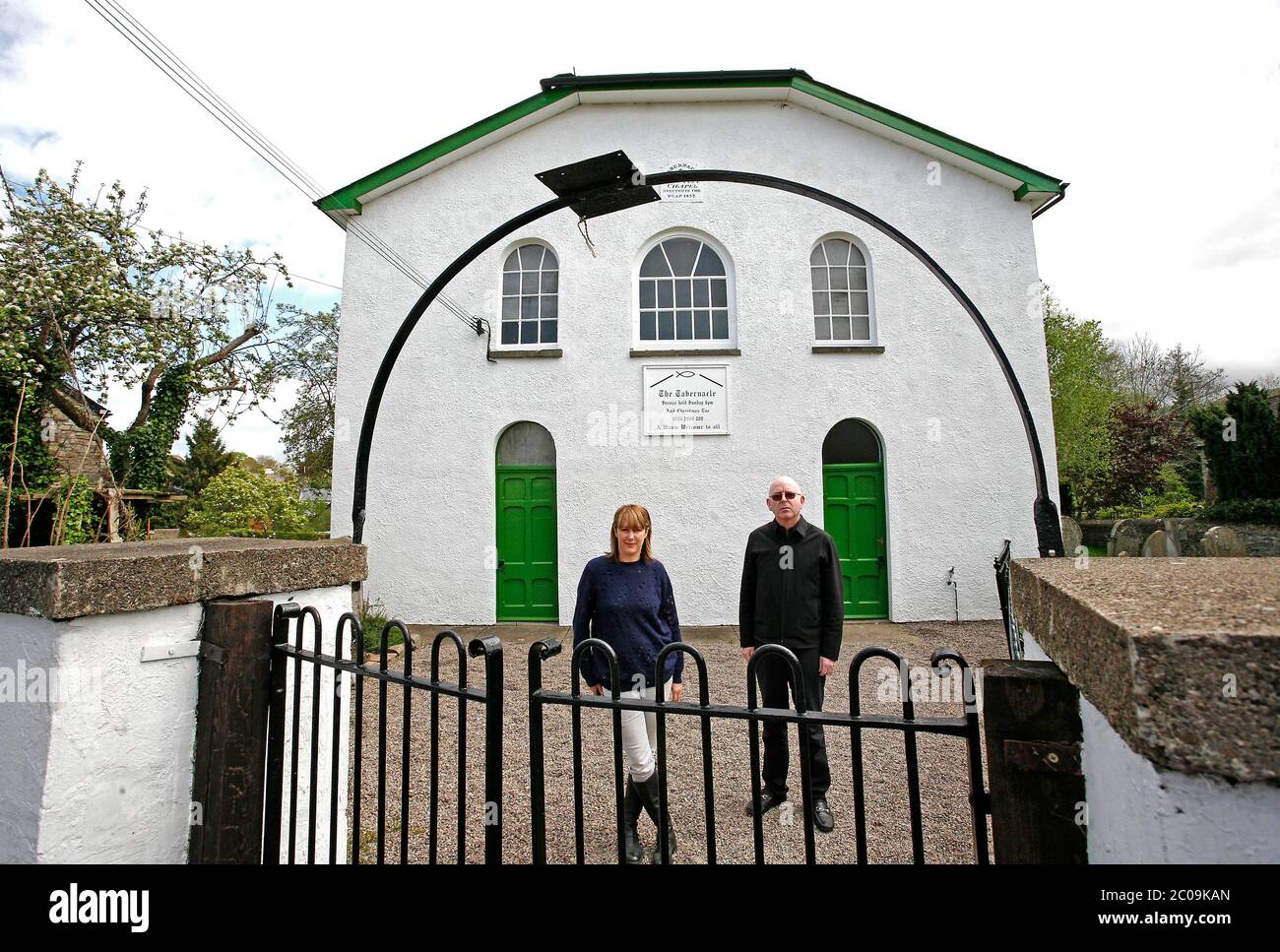 Alan McGee l'homme d'affaires écossais et le cadre de l'industrie musicale photographiés avec son partenaire devant la chapelle du Tabernacle à Talgarth, qu'il a achetée Banque D'Images