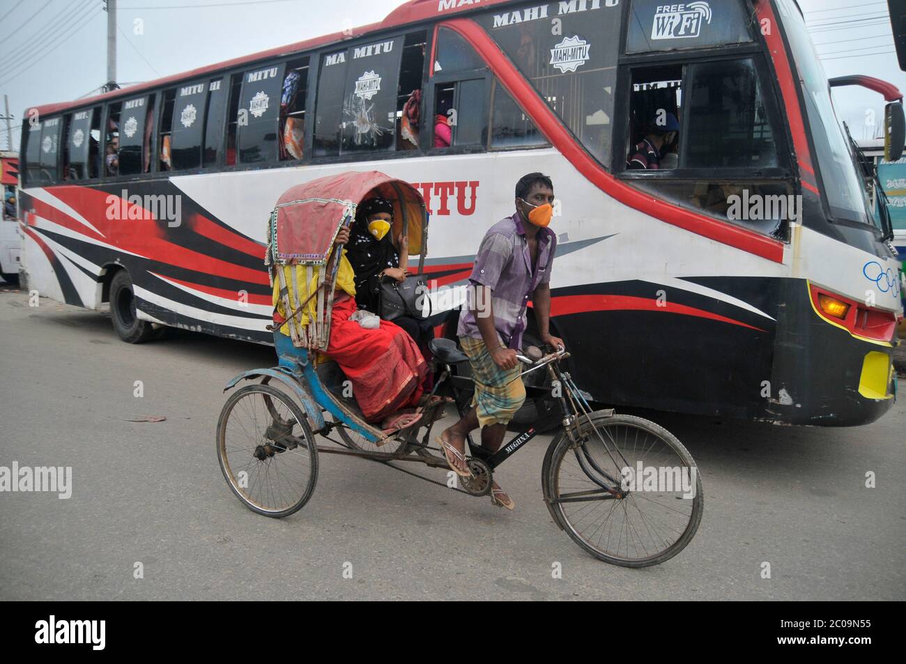 Les passagers portent un masque sur Rickshaw dans la rue de Sylhet, au Bangladesh Banque D'Images