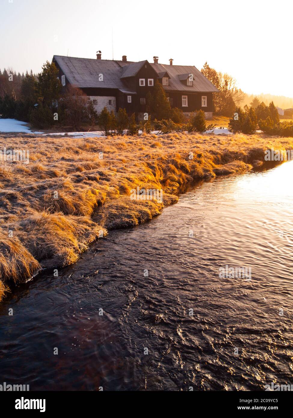 Cabane de montagne dans les premiers faisceaux de soleil levant. Matin de montagne libre en hiver. Banque D'Images