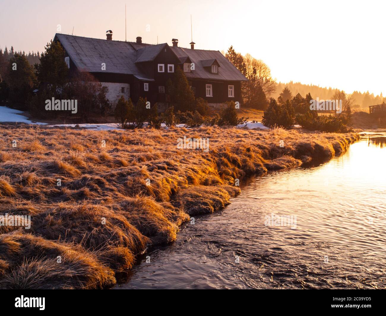 Cabane de montagne dans les premiers faisceaux de soleil levant. Matin de montagne libre en hiver. Banque D'Images