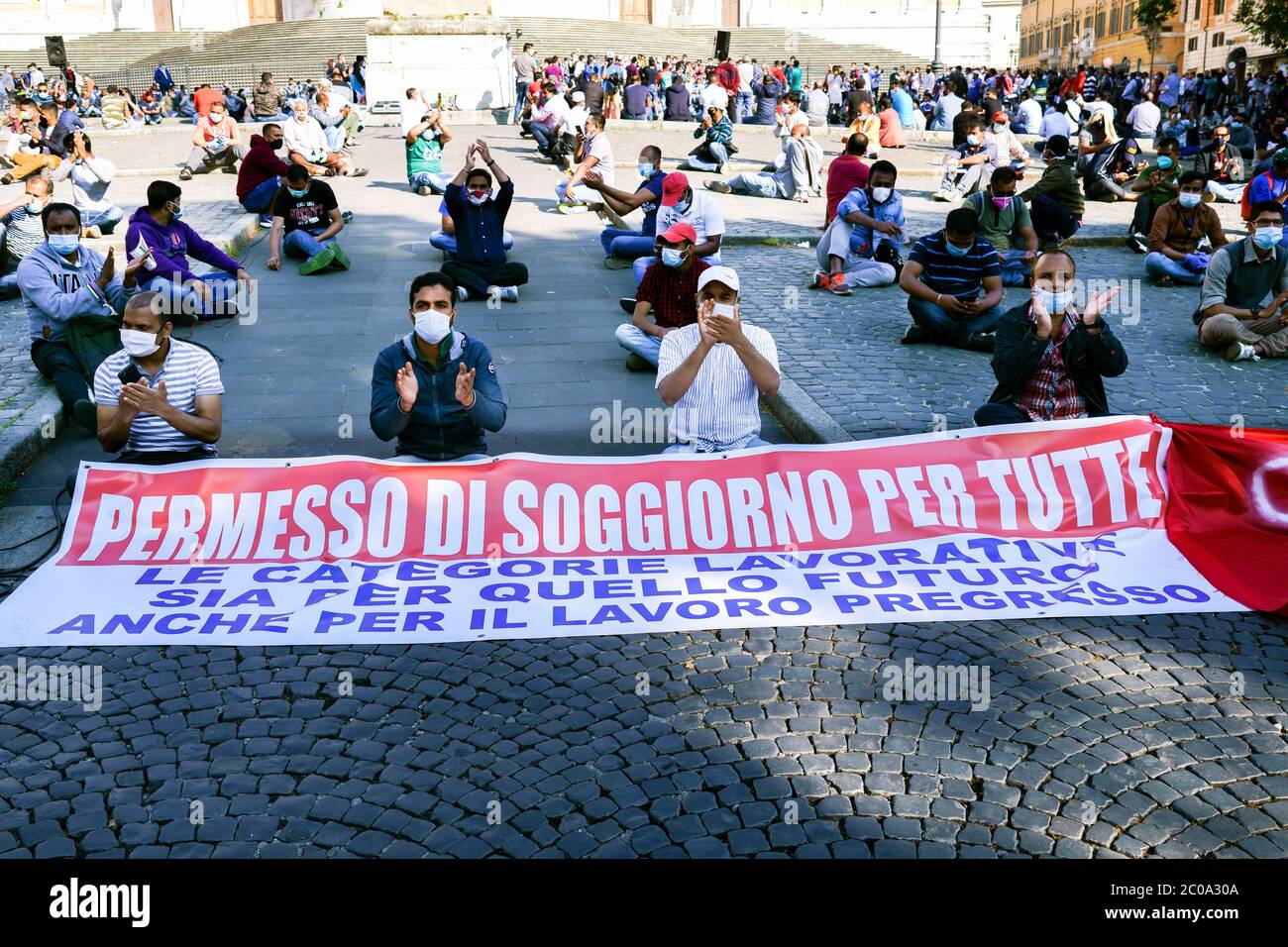 Immigrants non membres de l'UE lors d'une manifestation pour demander un permis de travail pour l'Italie. Ils portent des masques médicaux pour le coronavirus Covid 19. Rome au temps de Covid 19, Italie, Europe, Union européenne, UE. Banque D'Images