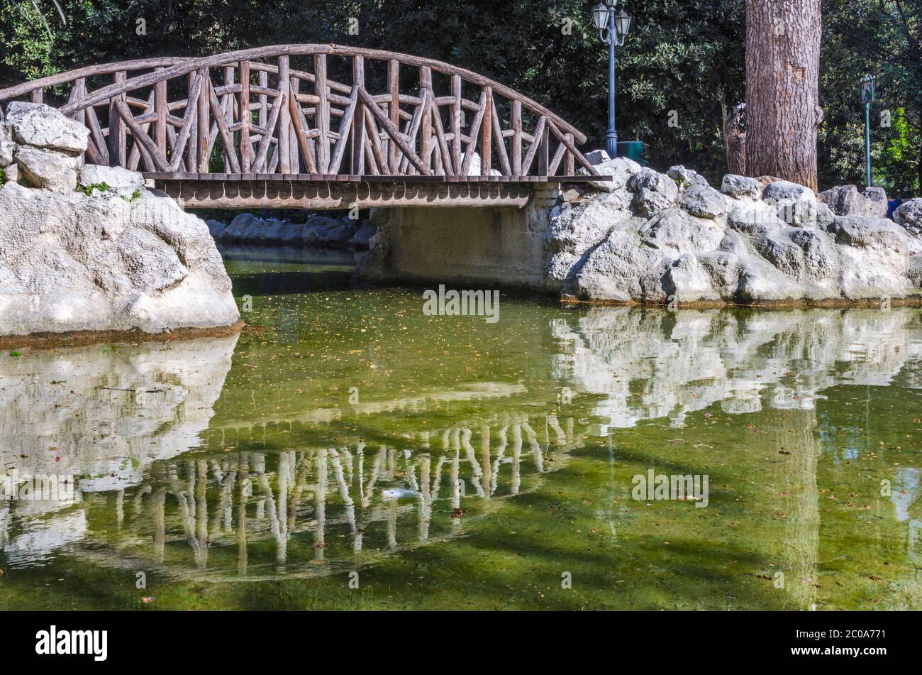 Le petit lac artificiel avec le pont en bois qui se reflète sur le lac au jardin national public peek à Athènes Grèce Banque D'Images