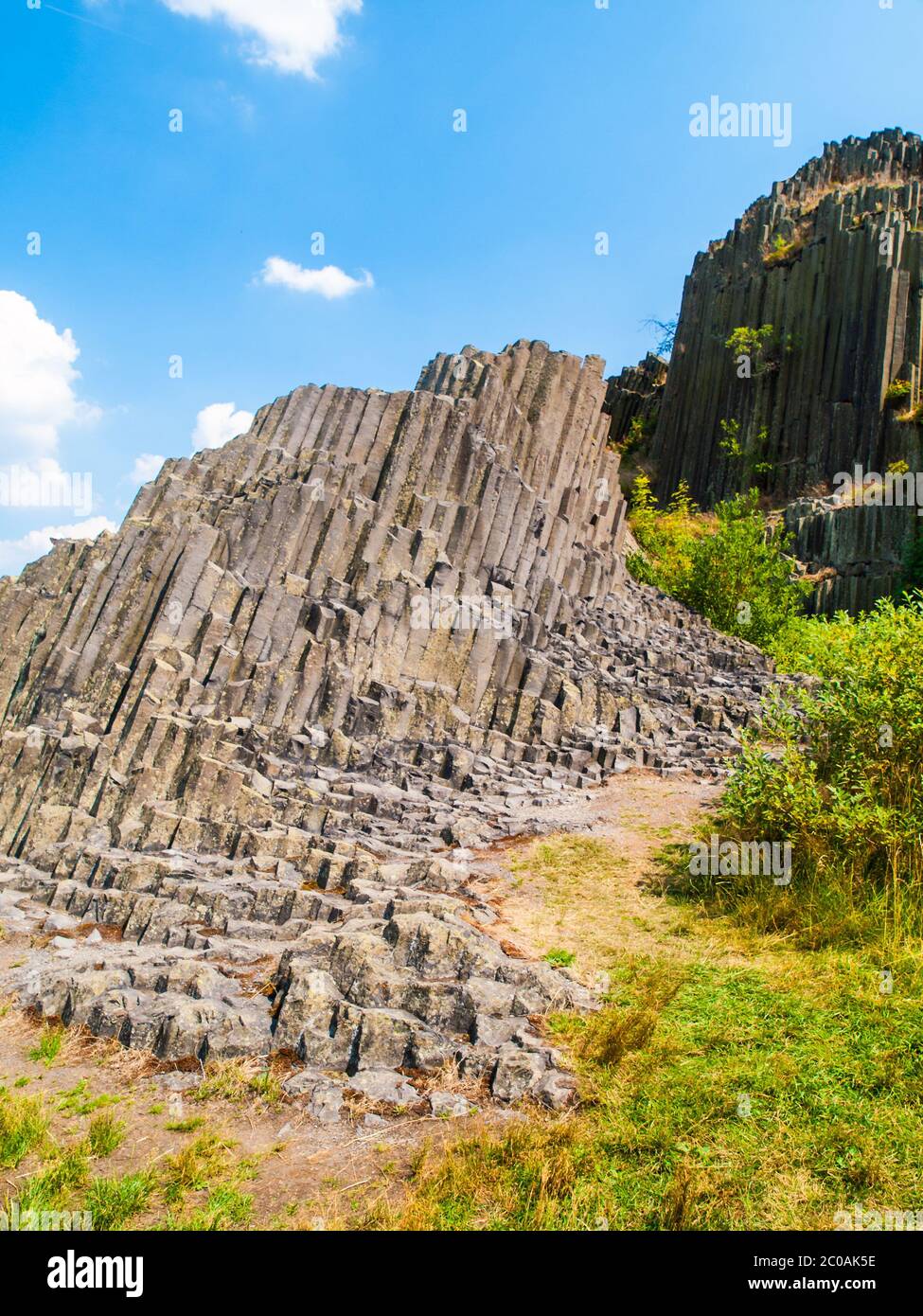 Unique en son genre, le basalte de pipes d'orgue formation rocheuse de Panska skala près de Kamenicky Senov en Bohême du Nord, République tchèque, Europe. Tourné le jour d'été ensoleillé avec ciel bleu et nuages blancs. Banque D'Images