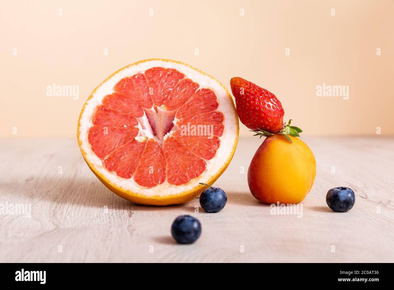 composition de fruits avec baies, pamplemousse et abricot sur une surface en bois isolée sur beige Banque D'Images