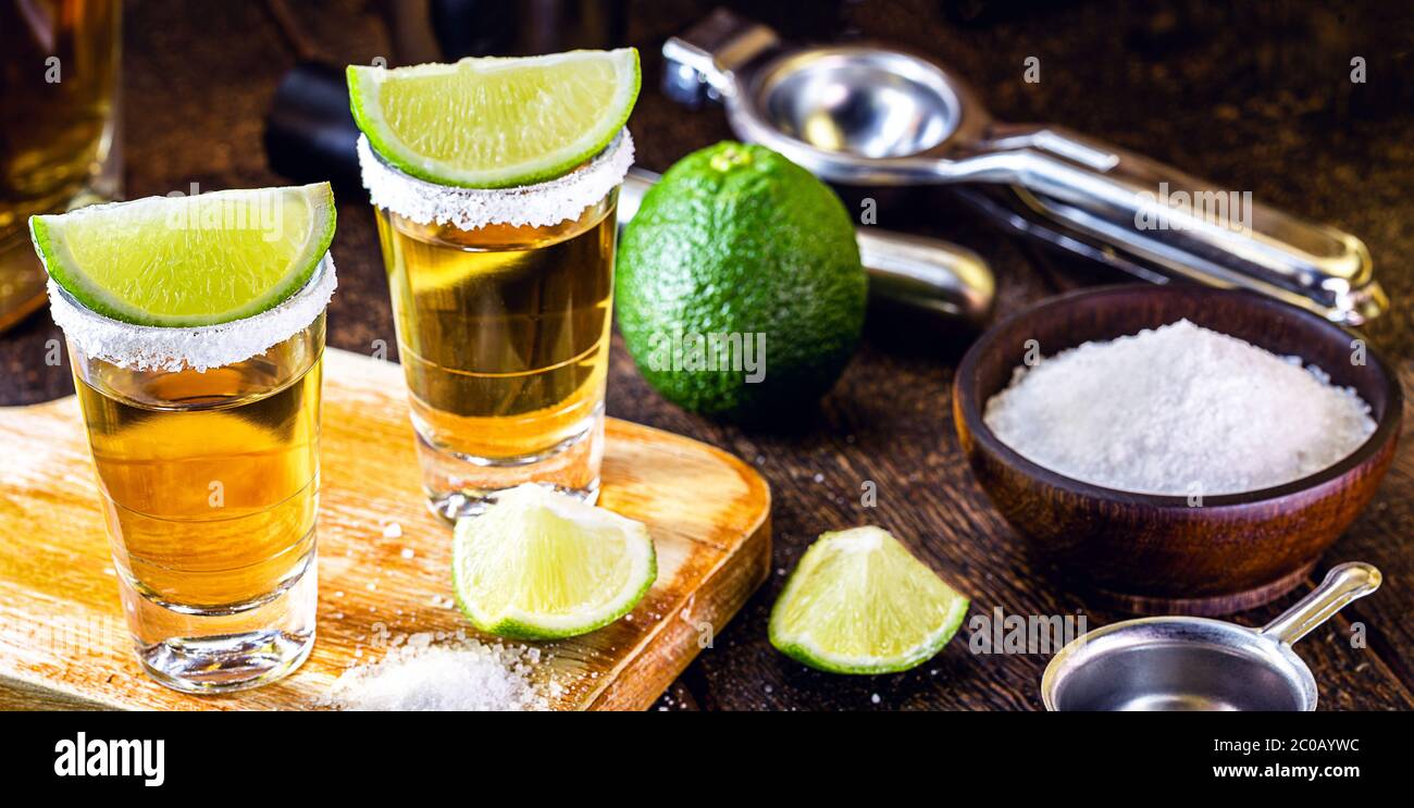 Tequila d'or mexicain au citron et au sel sur fond de bois. Journée internationale de la tequila, bar-restaurant Banque D'Images