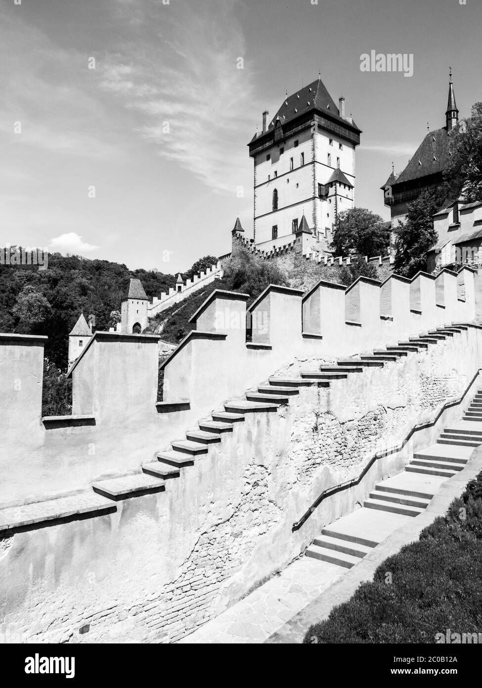 Château royal de Karlstejn, château gothique médiéval avec murs fortifiés le jour ensoleillé de l'été. République tchèque. Image en noir et blanc. Banque D'Images