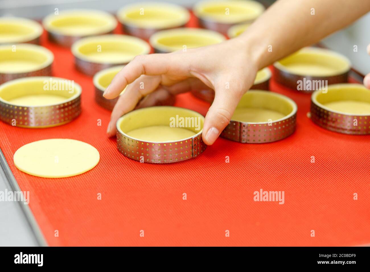 Préparer des tartes et des quiches sucrées ou salées. Cuisine nationale française. Fait à la main. Formation à la cuisine. Le cuisinier remplit le plat de cuisson avec la garniture. C Banque D'Images