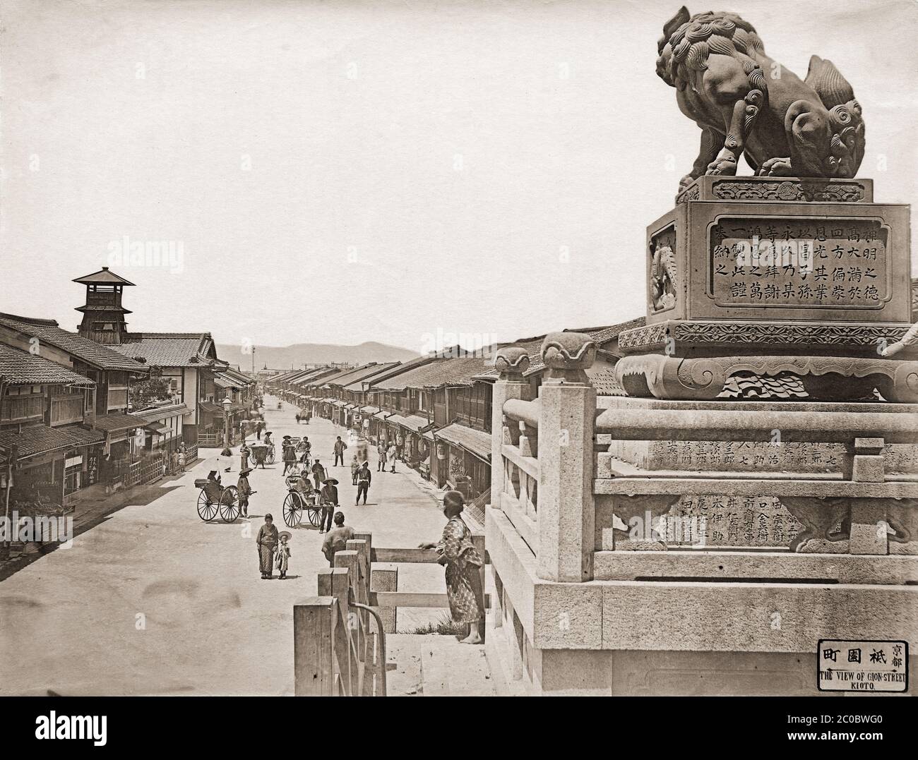 [ 1870s Japon - Gion, Kyoto ] — le quartier de divertissement de Gion à Kyoto vu des marches du sanctuaire de Yasaka. La rue est flanquée d'une multitude de maisons de thé où les clients peuvent apprécier la nourriture, la danse et la musique. La tour de gauche fait partie de l'école élémentaire Yasaka, créée en 1869 (Meiji 2). Les poteaux électriques ne sont pas encore en ligne. La compagnie d’électricité de Kyoto, Kyoto Dento Gaisha, a commencé ses activités en juillet 1889 (Meiji 22), et cette photo a donc été prise avant cette date. photographie d'albumine vintage du xixe siècle. Banque D'Images