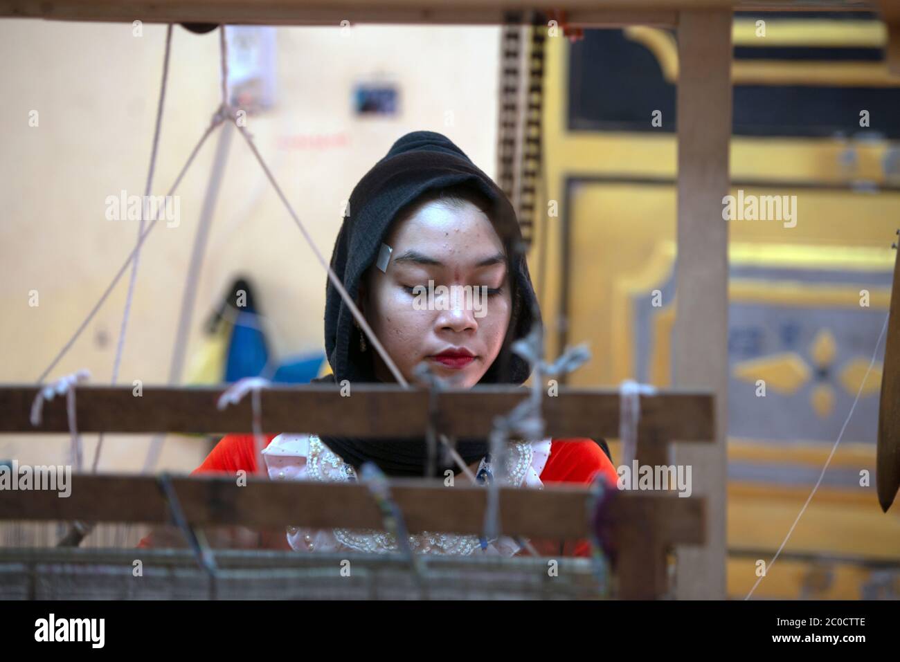 Une jeune femme autochtone de Cham est issue du tissage traditionnel dans son village près de Chau Doc, dans le sud du Vietnam. Banque D'Images