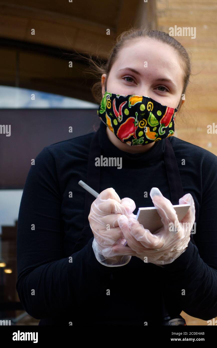 Le préposé à la livraison au café Latte vérifie la commande de nourriture avec un masque et garde la distance sociale. St Paul Minnesota MN États-Unis Banque D'Images