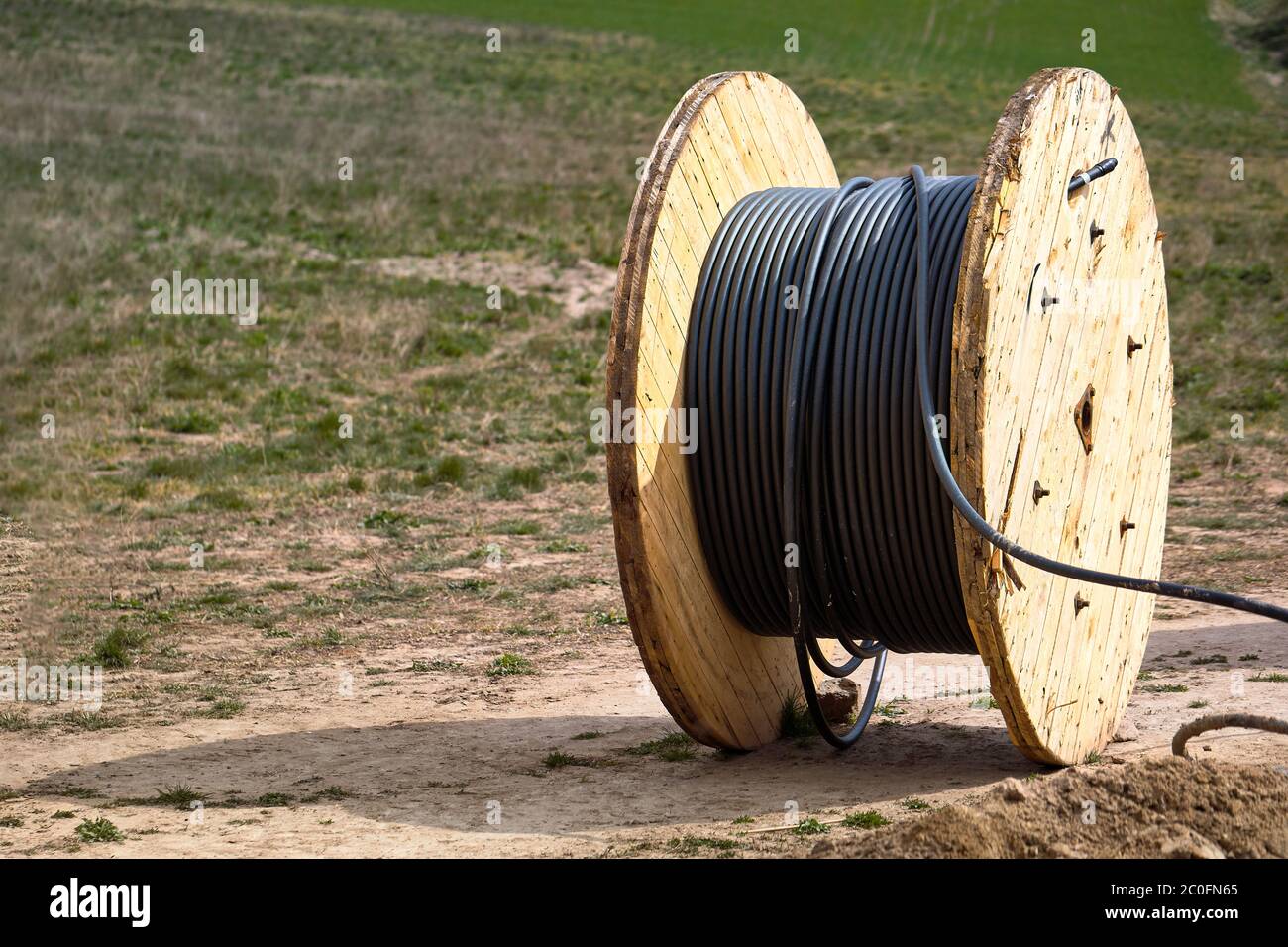 Concept de fourniture d'électricité pour les projets de construction. Bobine en bois avec câble d'alimentation. Banque D'Images