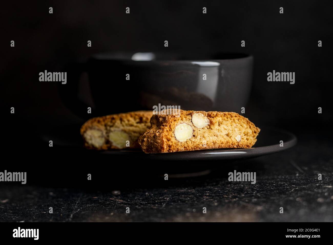 Biscuits italiens sucrés au cantuccini. Biscuits aux amandes sur une assiette noire. Banque D'Images
