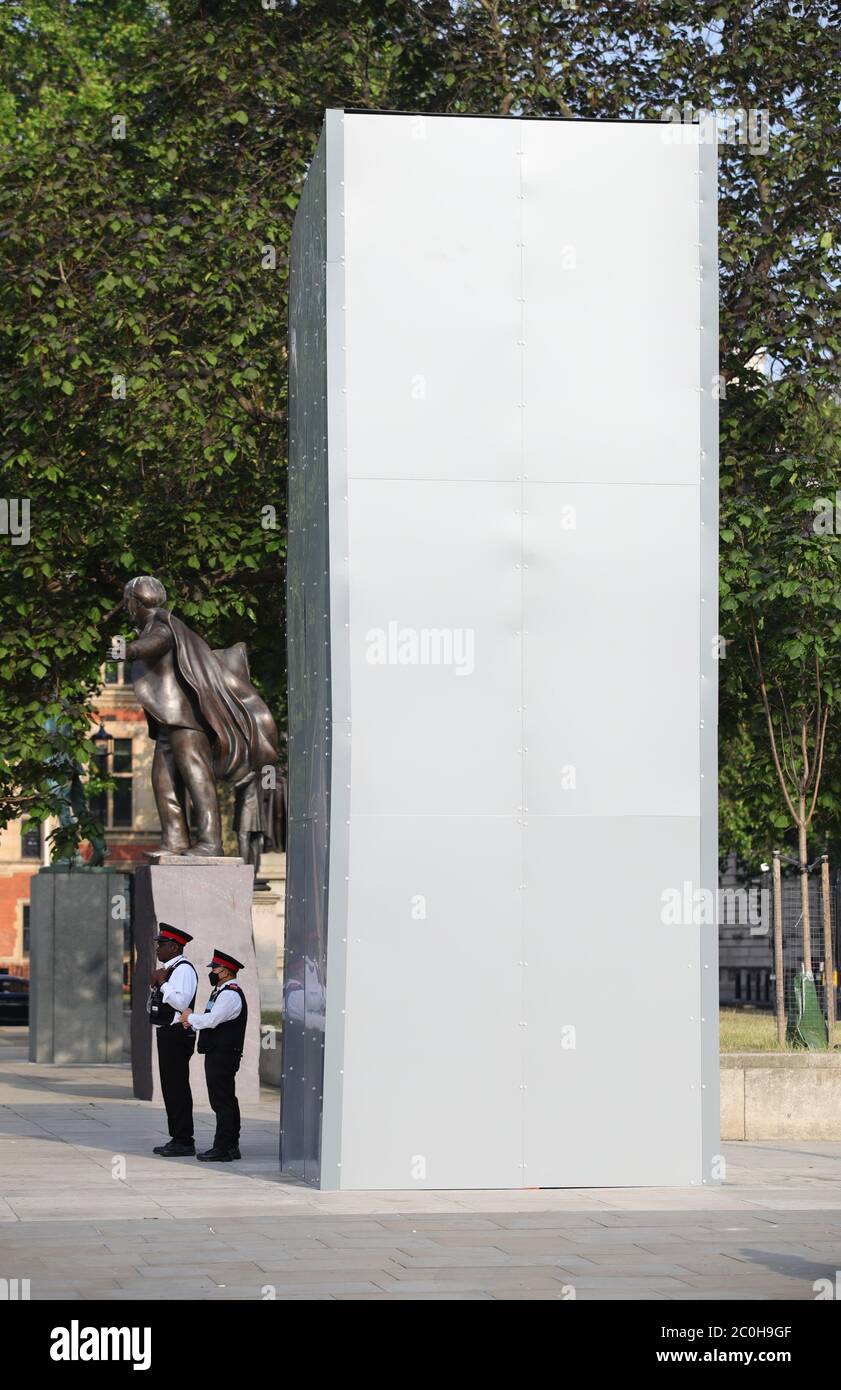 Les marshalls de la rue Westminster Council se trouvent à côté d'une couverture protectrice installée la nuit autour de la statue de l'ancien Premier ministre britannique Sir Winston Churchill sur la place du Parlement, à Londres, à la suite d'une série de manifestations Black Lives Matter qui ont eu lieu dans tout le Royaume-Uni pendant le week-end. Les manifestations ont été déclenchées par la mort de George Floyd, qui a été tué le 25 mai alors qu'il était en garde à vue dans la ville américaine de Minneapolis. Banque D'Images