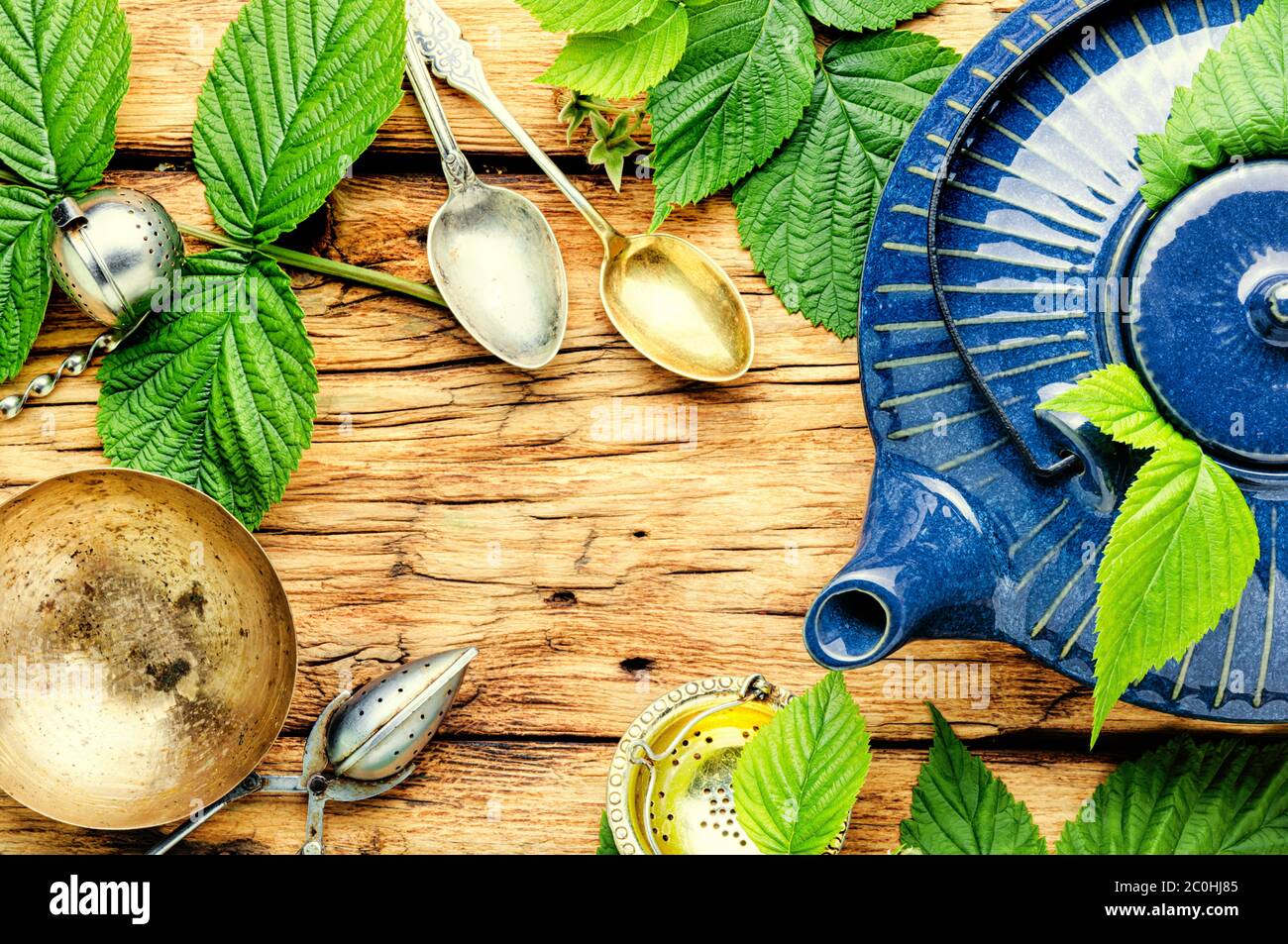 Thé parfumé à base de feuilles de framboise fraîche.théière en verre avec tisane.ingrédients pour thé aux herbes Banque D'Images
