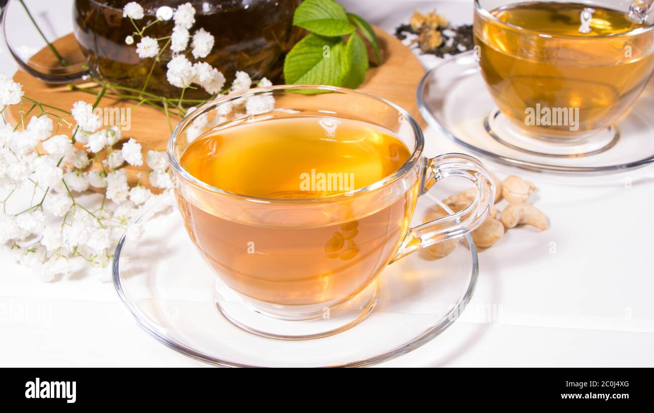 Thé aux fleurs avec tranches de fruits. Une tasse de thé vert et une théière. Cérémonie du thé, boisson traditionnelle. Thé de l'après-midi, ambiance chaleureuse. Pose à plat. Orientale, confortable, pré Banque D'Images