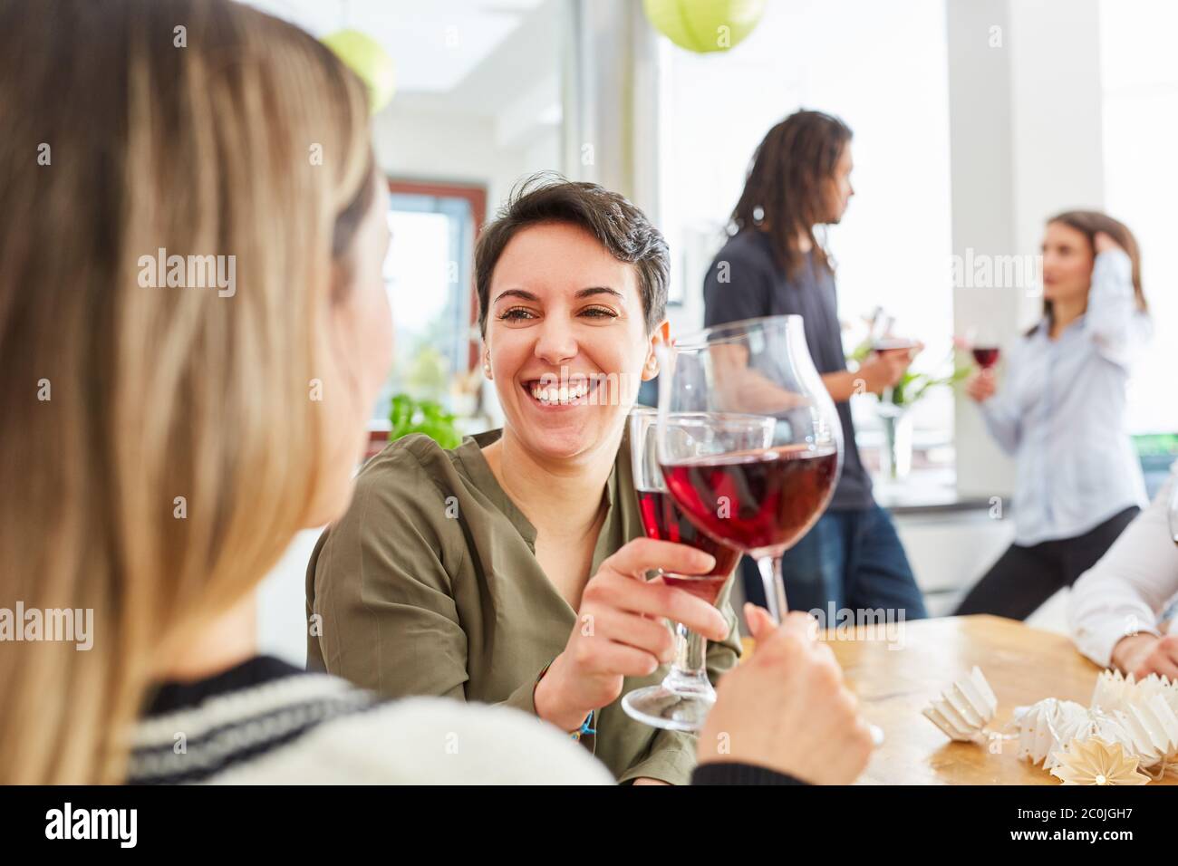 Deux femmes comme amis toasts avec un verre de vin rouge dans la cuisine Banque D'Images