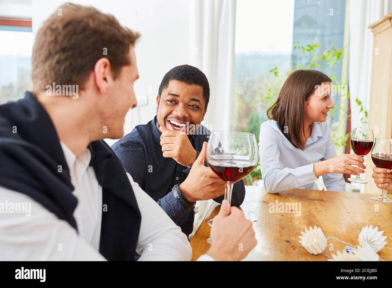 Deux hommes parlent l'un à l'autre avec un verre de vin lors d'une fête d'anniversaire Banque D'Images