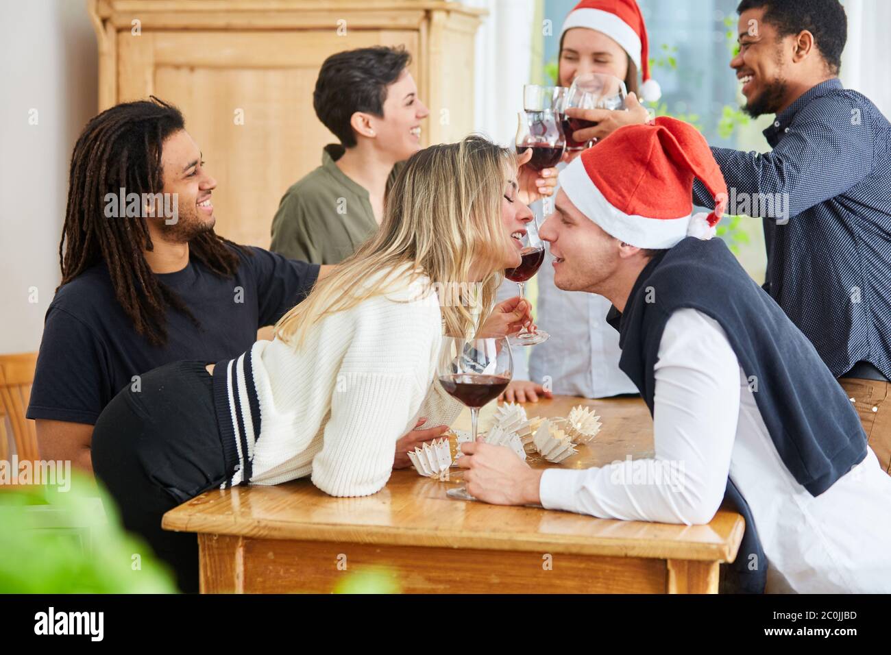Deux collègues s'embrassent lors d'une fête de Noël depuis le bureau tout en flirtant Banque D'Images