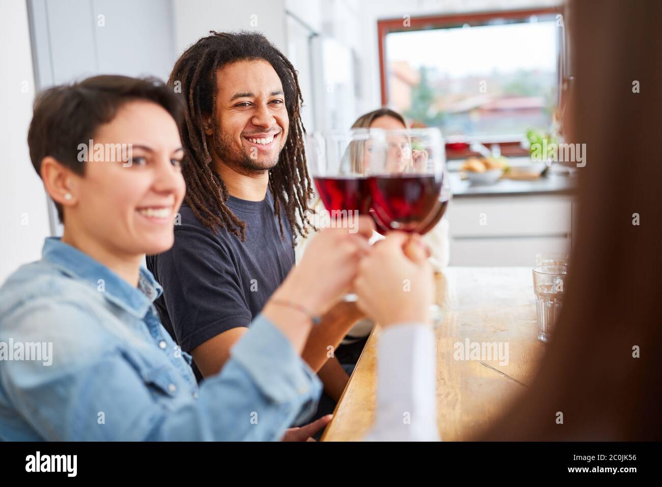 Un groupe d'amis heureux à la maison en dégustant un verre de vin rouge Banque D'Images