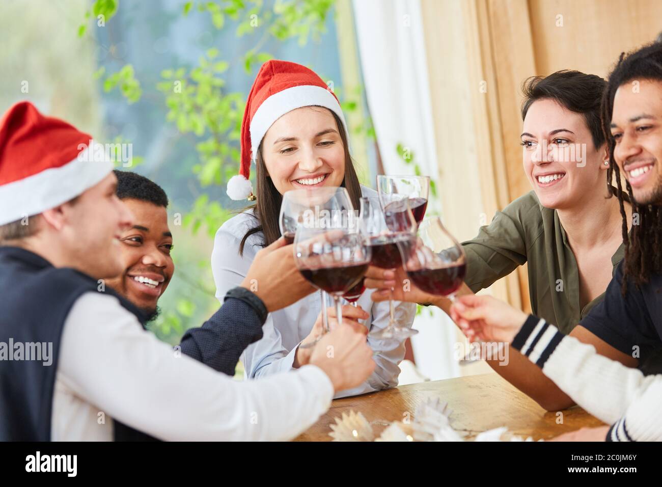 Entre Noël et Noël, les amis se sont rôrés avec un verre de vin rouge à la maison Banque D'Images