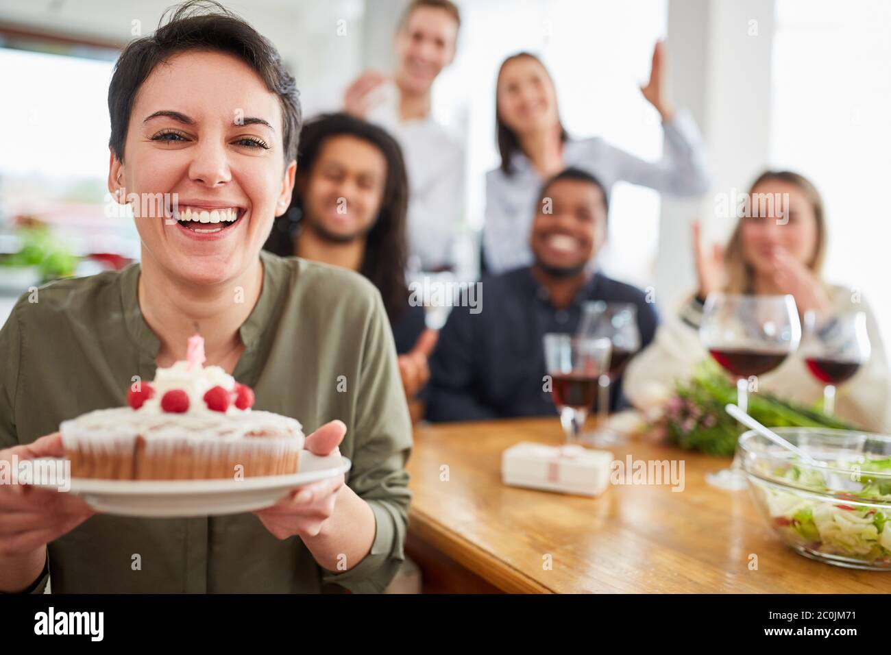 Gâteau de femme et bougie soufflée à la fête d'anniversaire avec des amis à la maison Banque D'Images