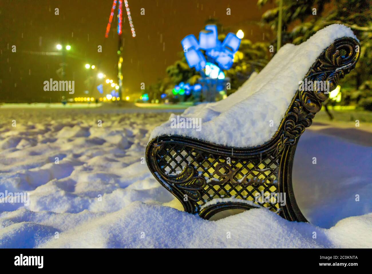 Parc d'hiver dans la soirée couvert de neige avec une rangée de lampes vue de banc et lanterne brillante par le biais de neige. Paysage de nuit d'hiver - soir i Banque D'Images