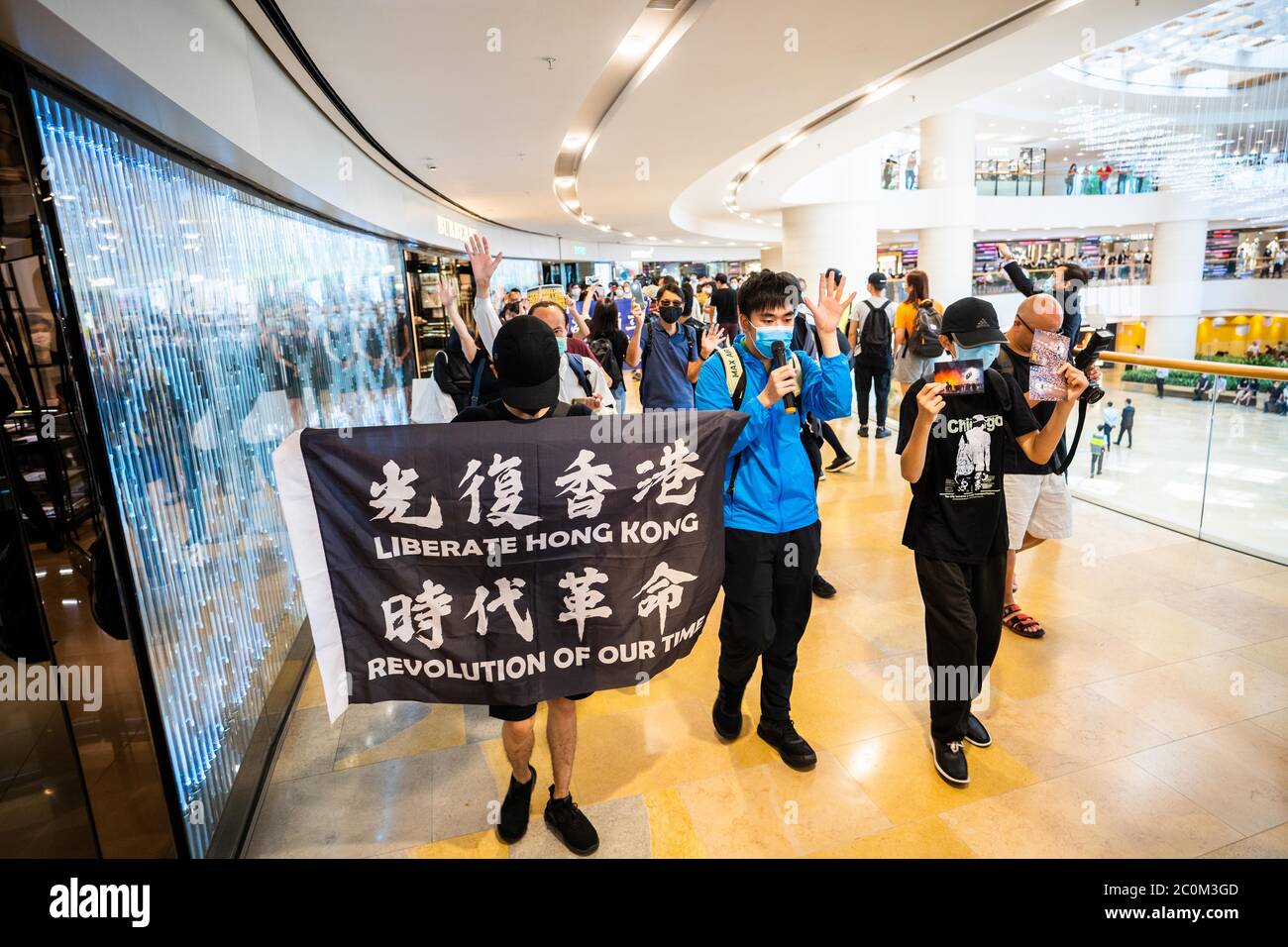 Les manifestants ont un drapeau et défilé dans un centre commercial du quartier central pendant la manifestation.les manifestants pro-démocratie ont organisé une manifestation dans le centre commercial Pacific place du quartier central de Hong Kong pour marquer le premier anniversaire du début du mouvement anti-gouvernement à grande échelle déclenché par Le projet de loi d'extradition que beaucoup croient sera utilisé comme un outil politique pour taire les ennemis politiques de la Chine à Hong Kong. Banque D'Images