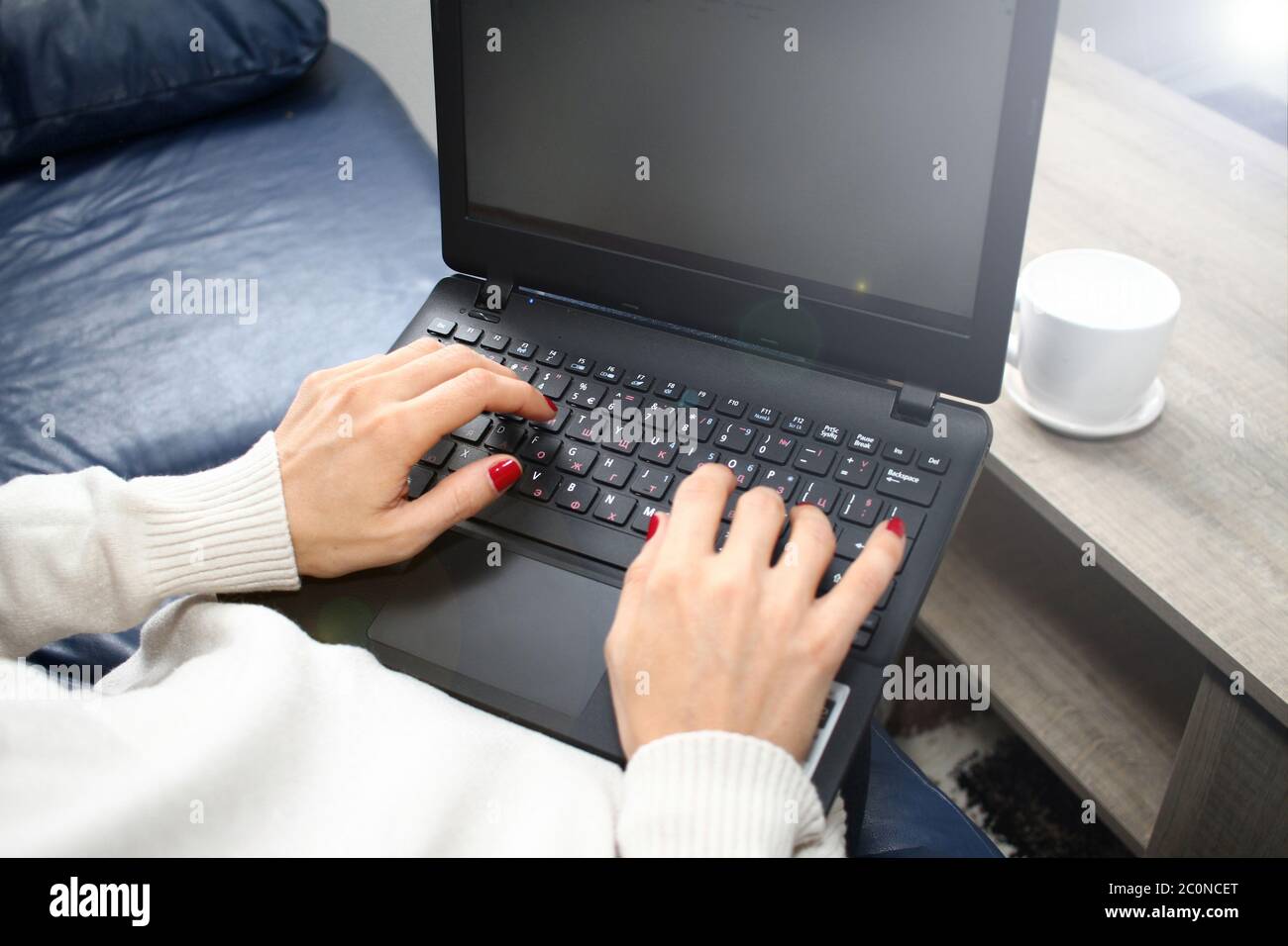 Femme mains avec ongles rouges est taper sur le clavier sur un ordinateur  portable avec tasse de café devant elle. Bureau à domicile Photo Stock -  Alamy