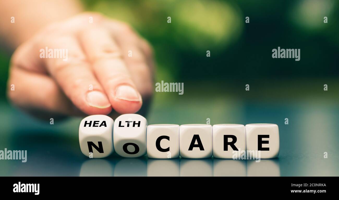 La main tourne les dés et change l'expression « aucun soin » en « soins de santé ». Banque D'Images