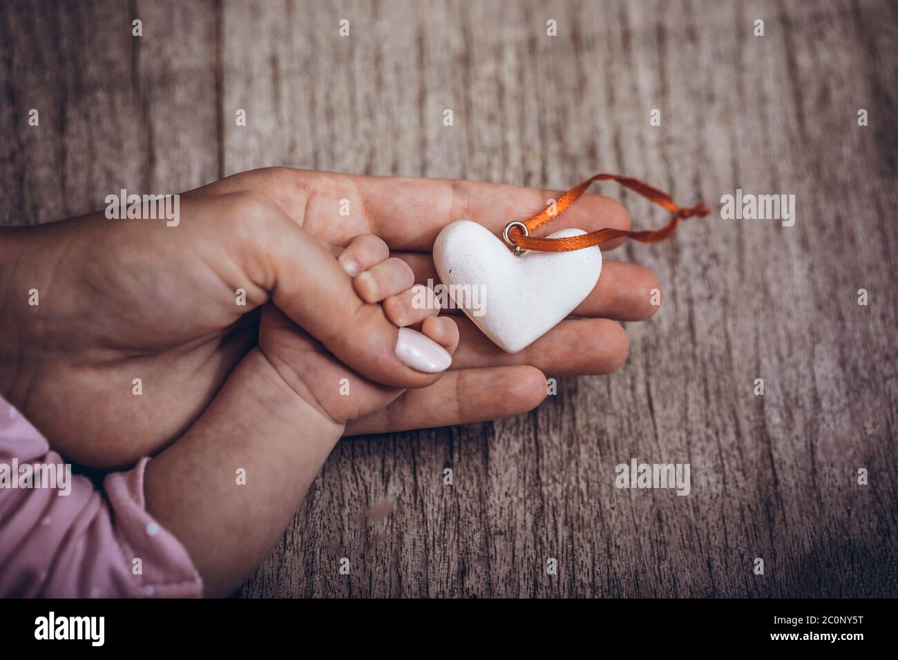 Mains des femmes tenant la main de l'enfant avec un cœur. Placer pour le  texte. Journée mondiale de l'humanitaire. Le concept de maternité, de soins,  de famille, de protection, lo Photo Stock -